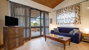 A living room with a television, a sofa, a coffee table, and a cabinet. - Villa 'Sunflower' with Private Garden and Wi-Fi (Capalbio)