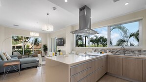 A modern kitchen with a large island, a built-in oven, and a stainless steel range hood. - Eagle Beach Resort Ground Level 3BR2BA Pool Levent (Oranjestad)