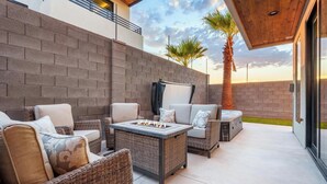 An outdoor patio with wicker furniture, a fire pit, and a view of the sky. - Desert Sands at Pecan Valley Resort  (Hurricane)
