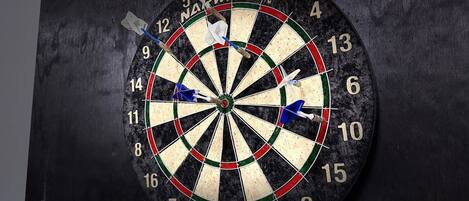 A dartboard with multiple darts stuck in it.