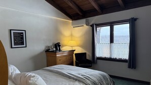 A bedroom with a bed, a dresser, a chair, a window with curtains, and a framed certificate on the wall. - Davos Chalet (Upson)