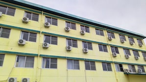 A multi-story building with air conditioning units installed on each window. - Hotel Sunrise (Onagawa)