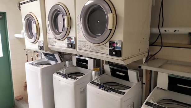 A laundry facility with multiple washing machines and dryers. - Hotel Sunrise (Onagawa)