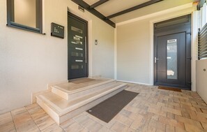 Enter through the entrance, featuring a set of steps and a doormat.