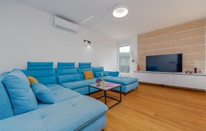 Relax in this stylish living room with a comfortable sofa, flat-screen TV, and decorative table.