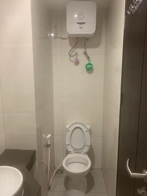 Compact bathroom with a toilet and sink, featuring a small window above the toilet.