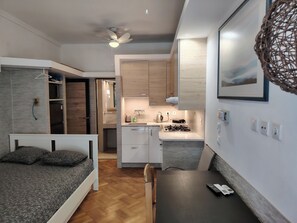 A compact, modern room with a bed, a small kitchenette, and a dining area. - Tritos - Sleeps 11 - Balcony - Parking - Sea View (Thessaloniki)