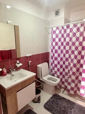 A bathroom with a sink, toilet, and shower curtain. - Appartement à beni mellal (Beni Mellal)