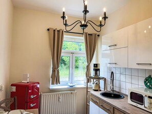 Mikrobølgeovn, ovn, oppvaskmaskin og spisebord