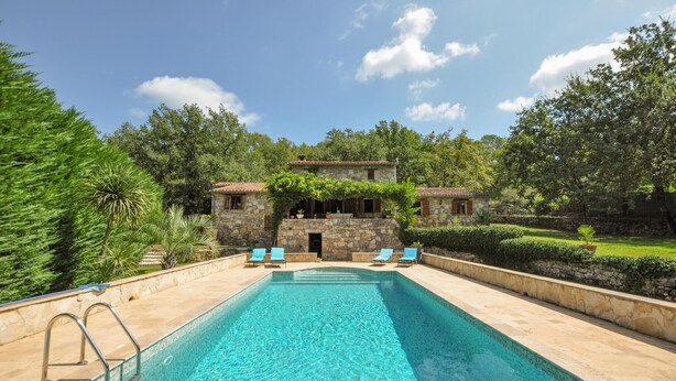 A swimming pool with a stone wall and a stone building in the background. - Amazing home in Fayence (Fayence)
