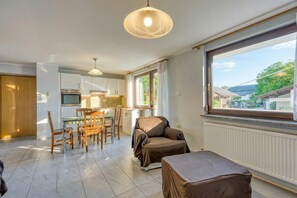 Une cuisine moderne avec un coin repas, un espace salon aménagé et une grande fenêtre offrant une belle vue.
