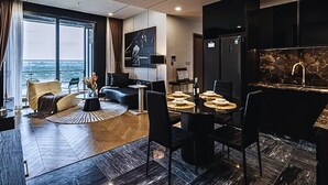 A modern living room with a sofa, coffee table, and dining area with chairs and a table set for four. - The Lumiere Luxury Citypoint ANGIA (Ho Chi Minh City)
