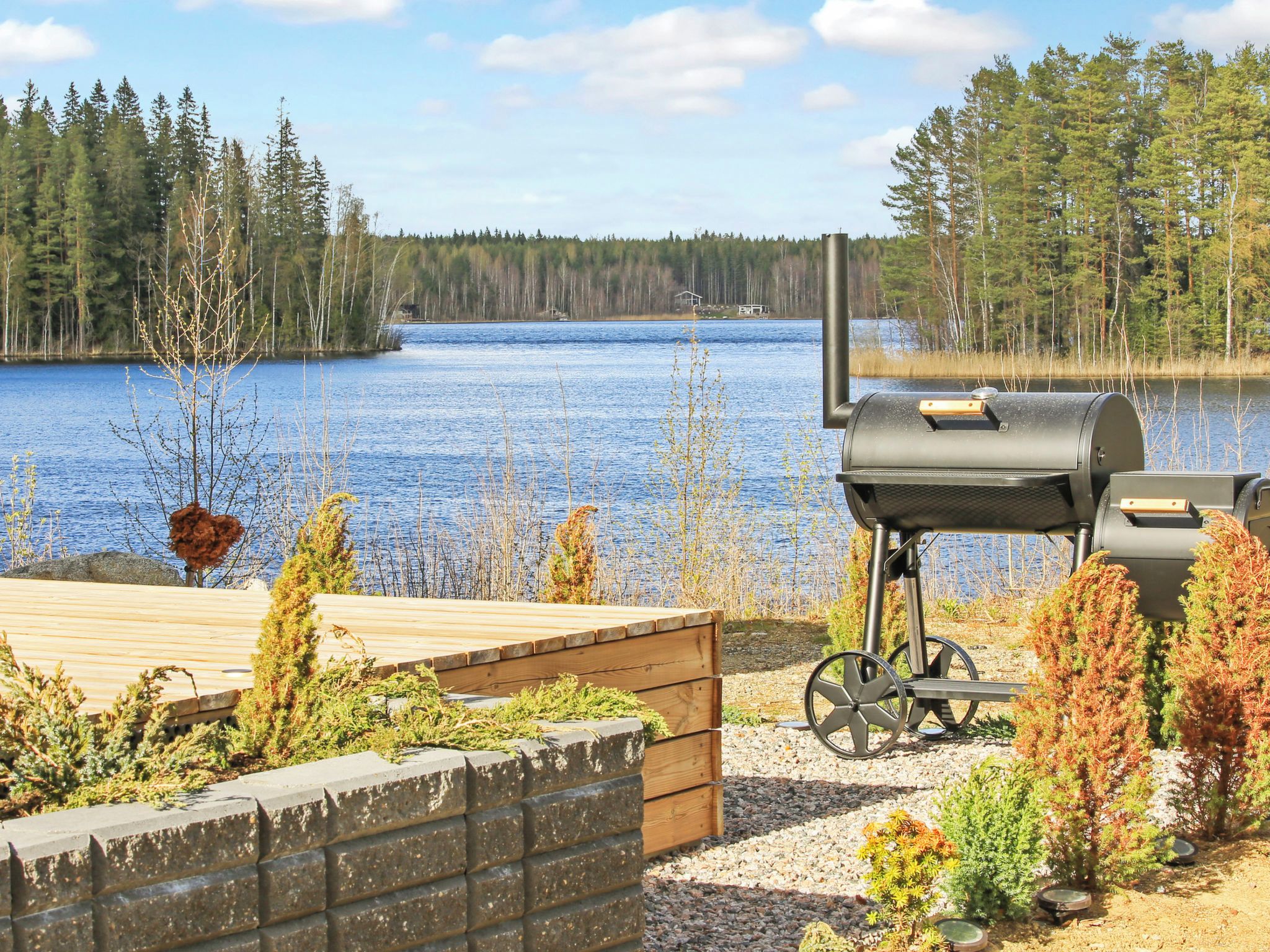 An outdoor deck with a grill and a view of a lake.