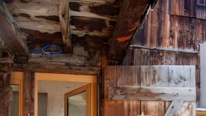 A rustic wooden door with a star decoration, a rope, and a metal latch. - Design chalet with Alpine panorama (Riom)