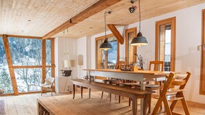 A wooden dining area with a bench, chairs, and a table. - Design chalet with Alpine panorama (Riom)