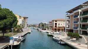 Un canal bordeado por barcos, un puente y edificios con balcones.