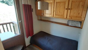 A room with a wooden cabinet, a bench, a window with a view, and a curtain. - Paradiski closed to the slopes vallandry (LANDRY)