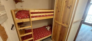A bunk bed with a red patterned mattress and a wooden headboard. - Paradiski closed to the slopes vallandry (LANDRY)
