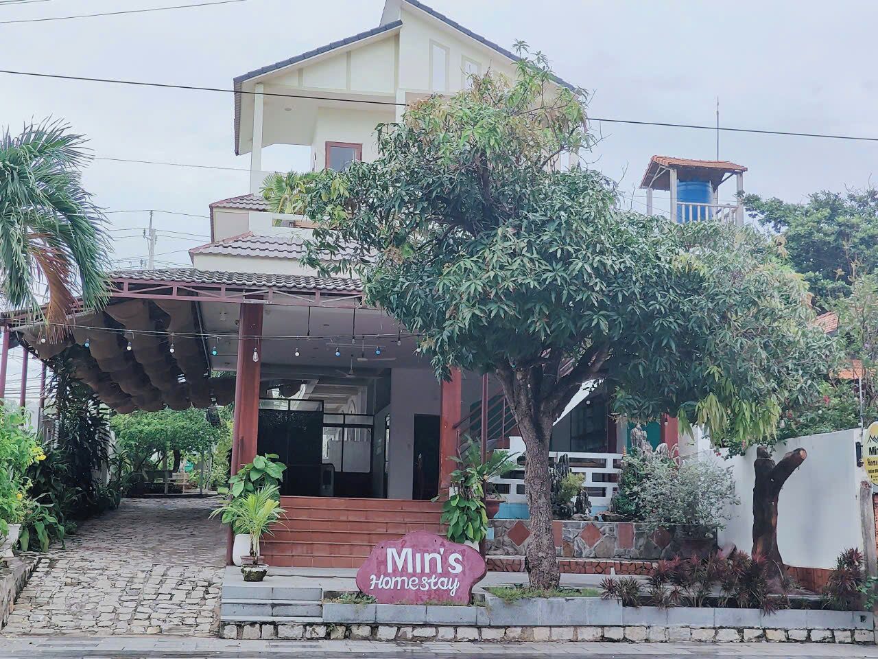Uma casa de dois andares com varanda coberta e uma placa com a inscrição 