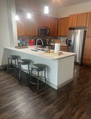 Enjoy cooking and dining in this well-equipped kitchen with a spacious island, sink, and bar stools.