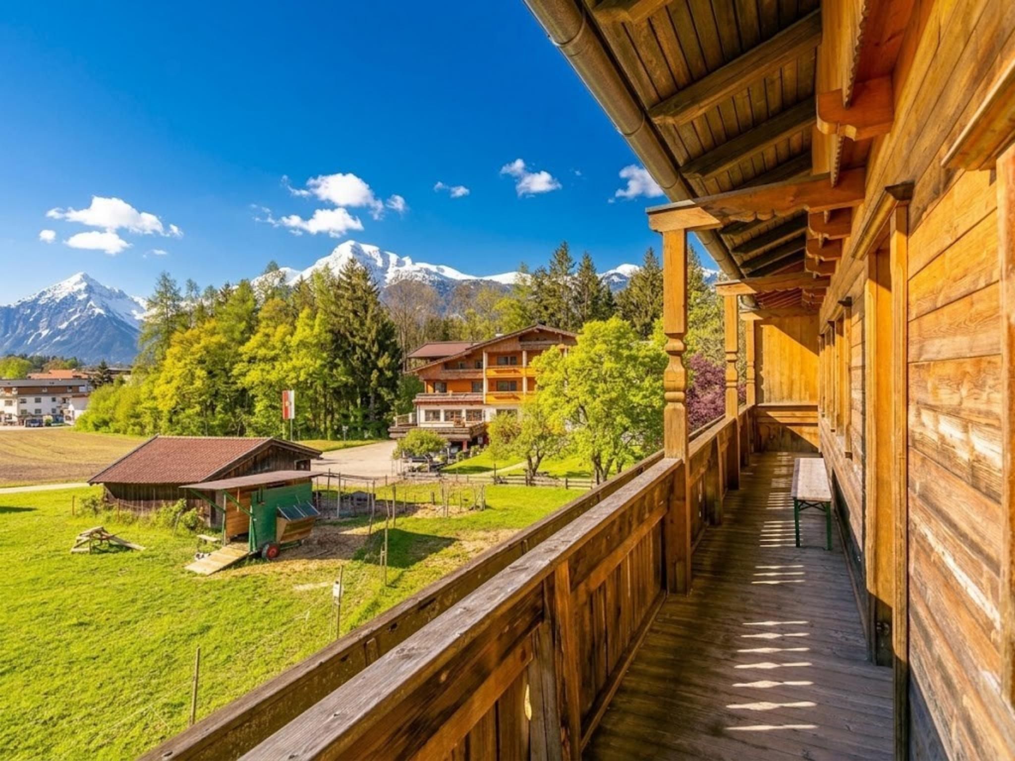 Un bâtiment en bois doté d’un balcon donnant sur un paysage verdoyant et des montagnes.