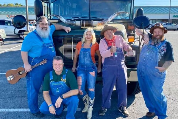 A group of people posing in front of a truck.