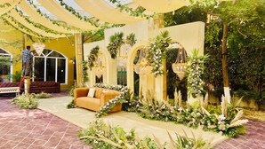 Un jardín interior con sofá, plantas decorativas y una araña.