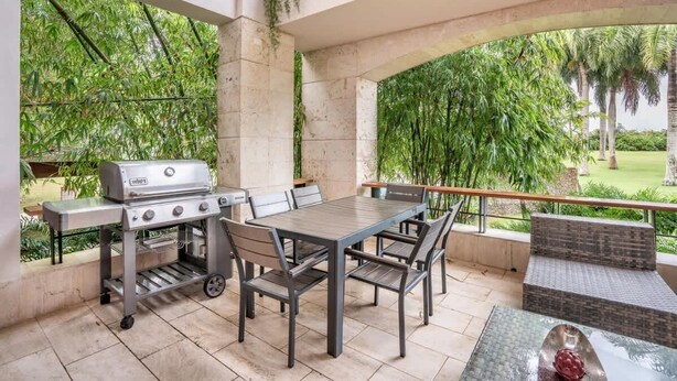 Terrassa exterior amb una barbacoa, taula de dinar, cadires i zona de seients.