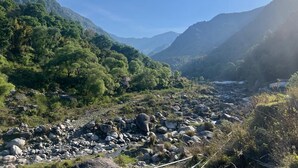 Eine gebirgige Landschaft mit Fluss, felsigem Gelände und üppigem Grün.