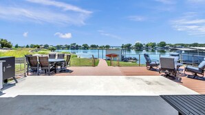 A deck with outdoor furniture overlooking a lake.