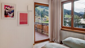 A room with a bed, a window with a view of a landscape, and two framed artworks on the wall. - Holiday Home 'Blueberry Haus Im Moos' with Mountain View, Shared Terrace and Wi-Fi (Oberau)