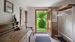 A hallway with a wooden bench, a door leading outside, a coat rack, and a small stool. - Chalet 'Berghof Moosen' with Mountain View, Private Terrace and Wi-Fi (Hart im Zillertal)