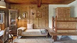 A rustic room with wooden walls, a bed, a cabinet, and a mirror. - Chalet 'Berghof Moosen' with Mountain View, Private Terrace and Wi-Fi (Hart im Zillertal)