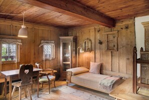 A rustic wooden room with a bed, a desk, a chair, and a cabinet. - Chalet 'Berghof Moosen' with Mountain View, Private Terrace and Wi-Fi (Hart im Zillertal)