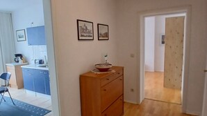 A hallway with wooden flooring, a wooden dresser, and two framed pictures on the wall. - Apartment 'Ingrid Bauer 2' with Wi-Fi (Kühlungsborn)