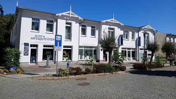 Ein Gebäude mit einem Schild für 'Kunst & Antiquitaten' und einem blauen Zebrastreifen.