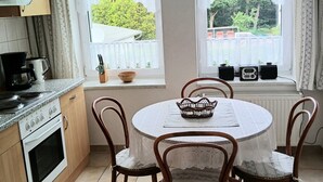 Eine Küche mit Esstisch, Stühlen und einer Pendelleuchte.