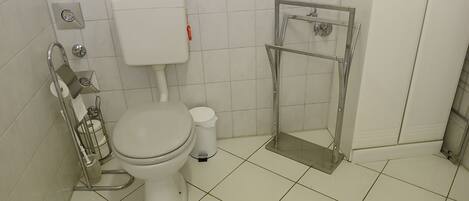 A bathroom with a toilet, a bidet, and a shower stall.