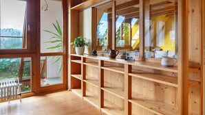 A wooden interior with large windows, a radiator, and a shelf with decorative items. - Apartment 'Fewo 1' with Wi-Fi (Müllheim im Markgräflerland)