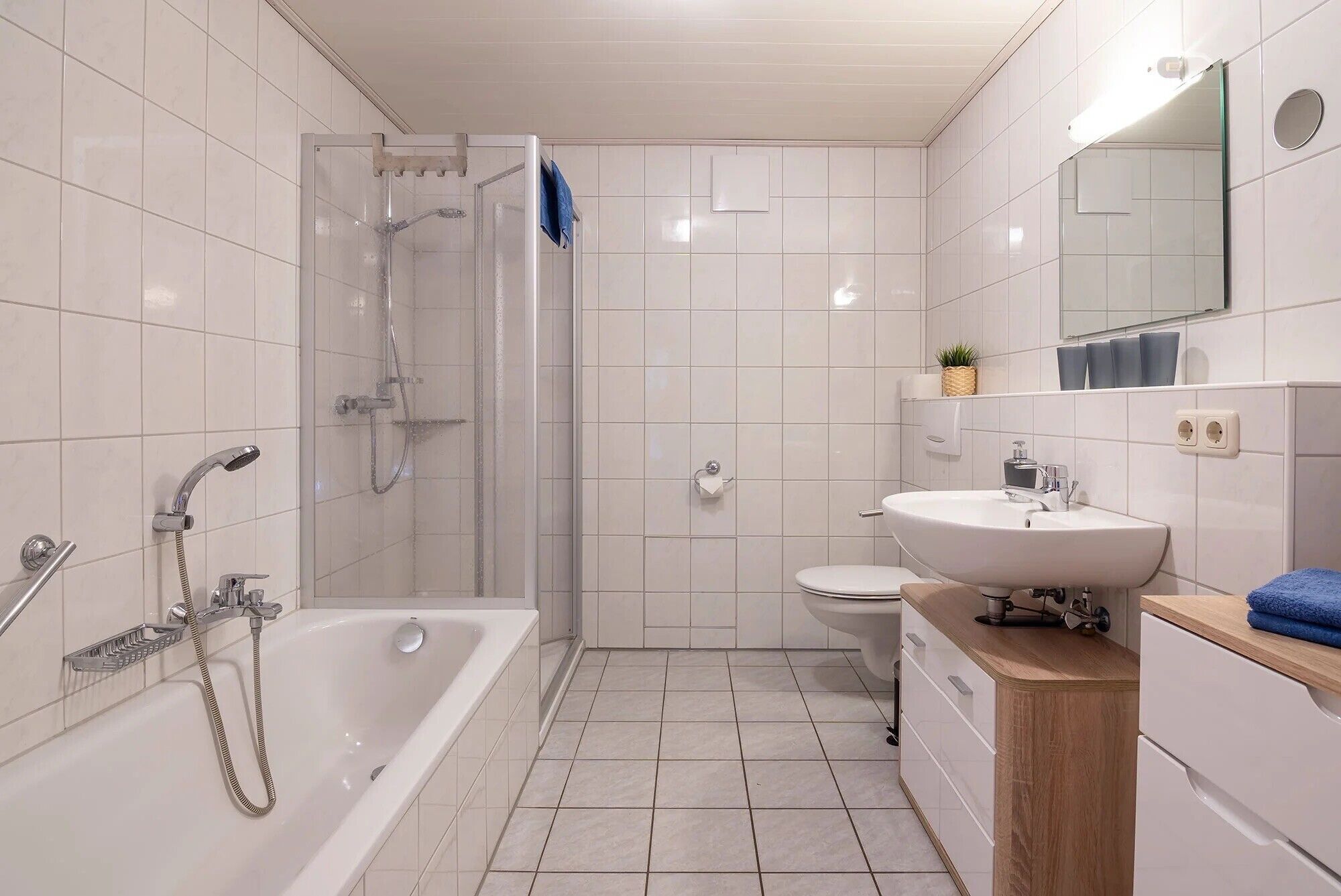 A modern bathroom with a shower, toilet, and sink.