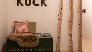 A room with a bed, a green chest, birch tree decorations, and a wall with the text 'KUCK KUCK'. - Apartment ‘Tannenhöhe’ with mountain view, balcony and Wi-Fi (Oppenau)