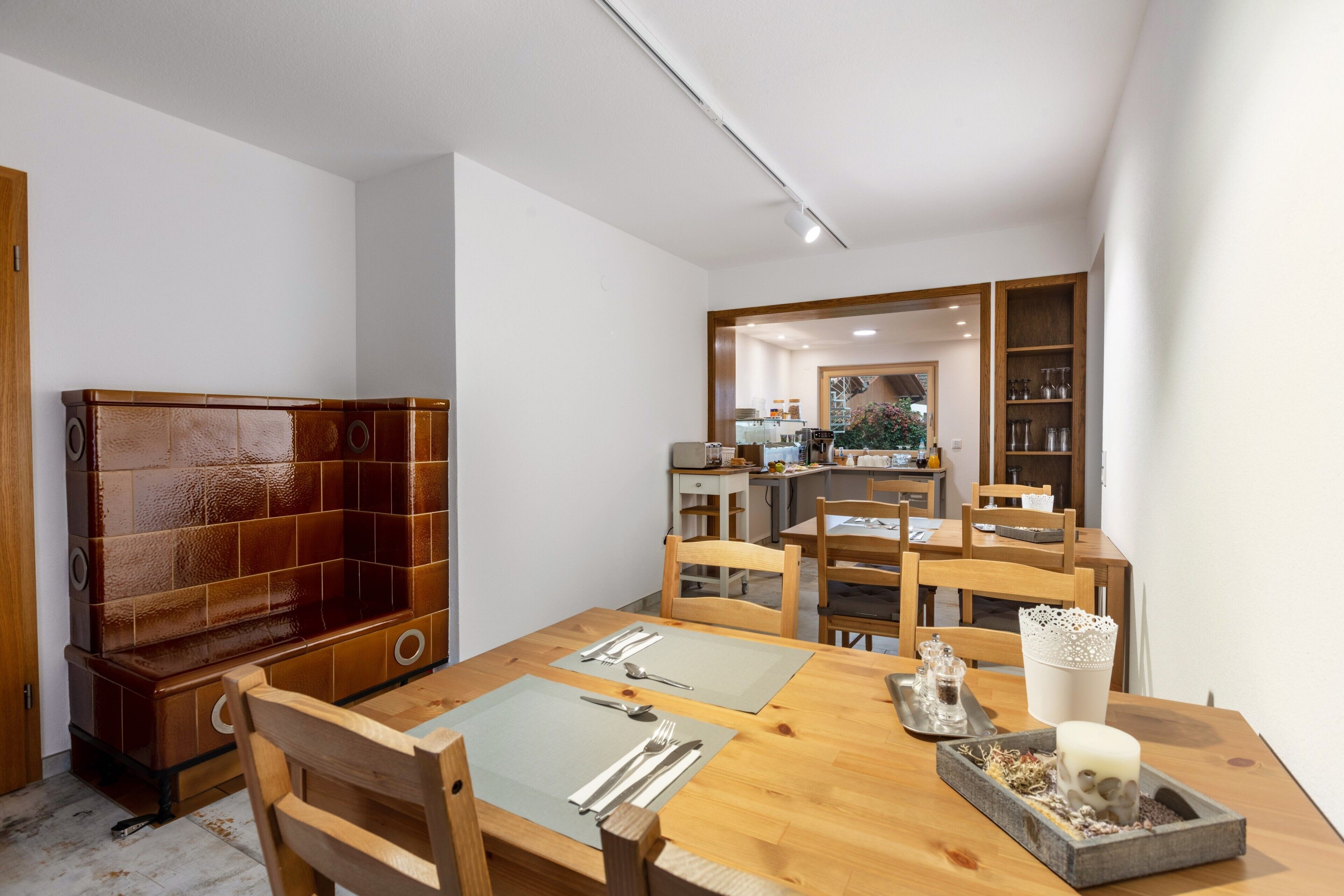Ein Essbereich mit Holztisch, Stühlen und einer Küche im Hintergrund.
