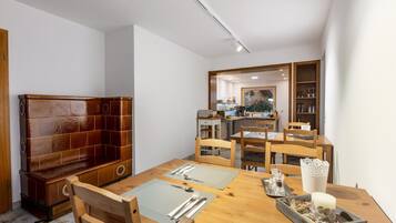 Ein Essbereich mit Holztisch, Stühlen und einer Küche im Hintergrund.