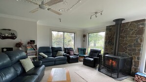 A living room with a fireplace, leather sofas, and a coffee table. - Enjoy Alpine Lifestyle at Mesley Manor, in heart of Omeo, close to Bike Trails (Omeo)