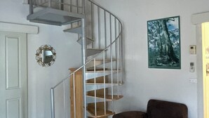 A room with a spiral staircase, a wooden chair, and a painting on the wall. - Enjoy Alpine Lifestyle at Mesley Manor, in heart of Omeo, close to Bike Trails (Omeo)