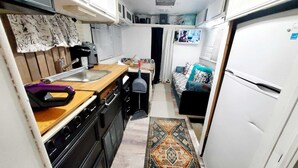 Una cocina compacta con un lavamanos, estufa y una pequeña zona de comedor.