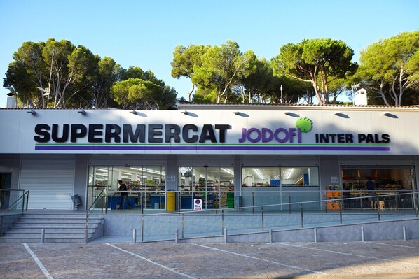 Et supermarked, der hedder 'SUPERMERCAT JODOFI INTER PALS', med en tydelig indgang og synlige hylder indeni.