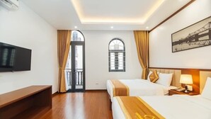A hotel room with two beds, a TV, a desk, and a window with curtains. - Quynh Anh Hotel Ha Long (Bai Chay)