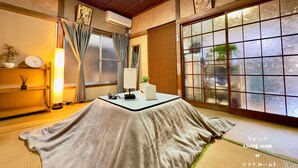 Een traditionele Japanse woonkamer met tatami vloeren, een lage tafel, een klok en een grote shoji-scherm.
