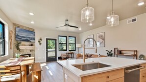 A spacious kitchen with a large island, wooden cabinets, and pendant lighting.
